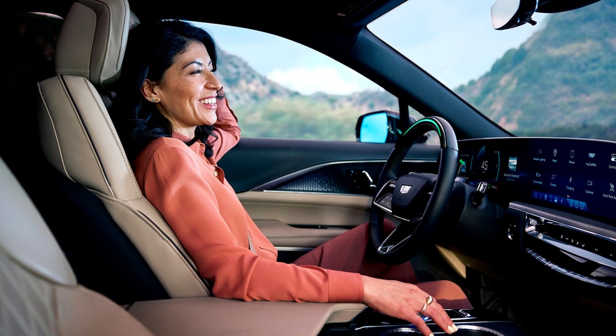 Une femme assise au volant d'une Chevrolet avec la superposition « MOTORTREND BEST TECH 2025 »