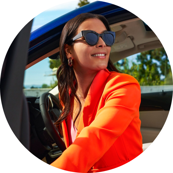 A woman wearing sunglasses stepping out of her vehicle