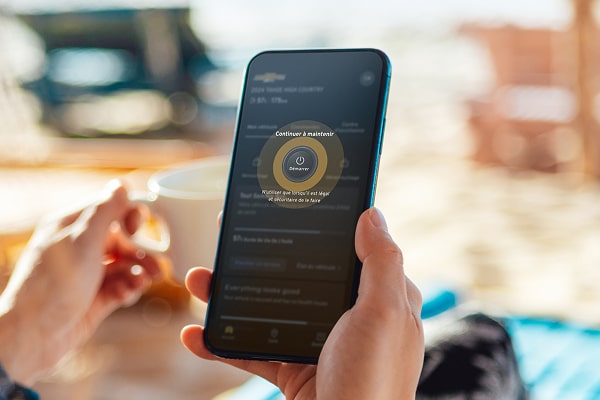 Une femme utilisant son smartphone pour utiliser les commandes à distance OnStar