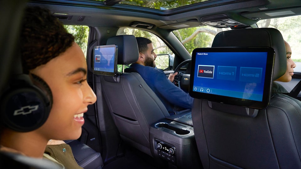 A young girl watching  Youtube on the rear seat entertainment system