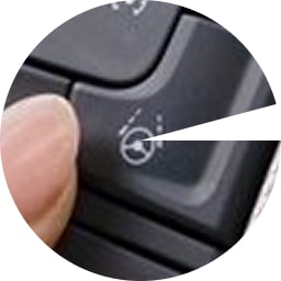 Close-up of a driver pressing the Super Cruise hands-free driving activation button.