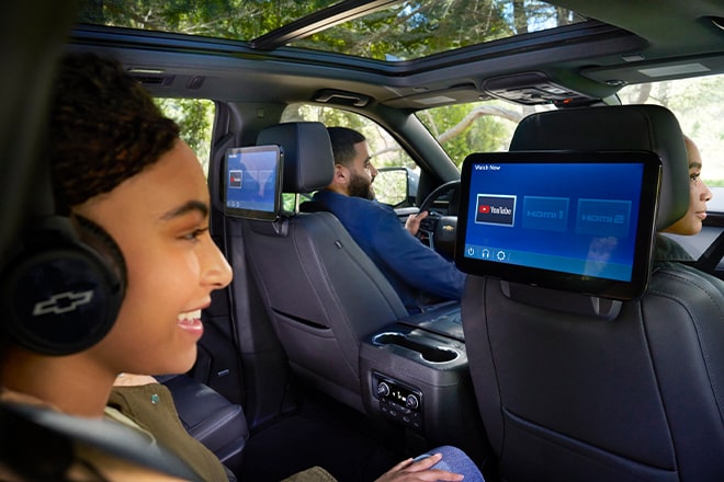 A young girl watching  Youtube on the rear seat entertainment system