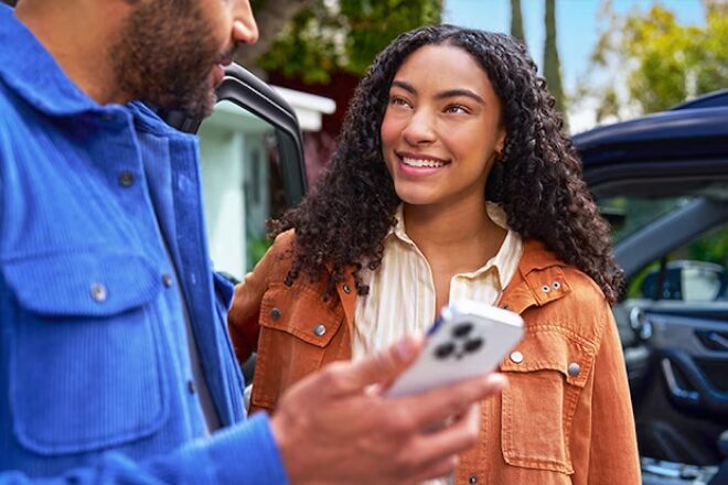A couple using a smartphone to use OnStar.