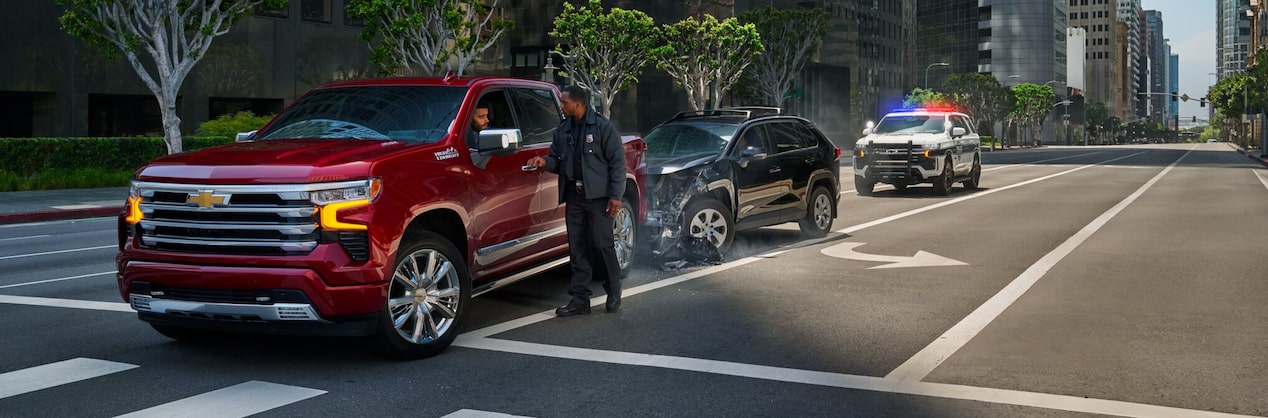 A public safety professional standing beside a Chevrolet vehicle.