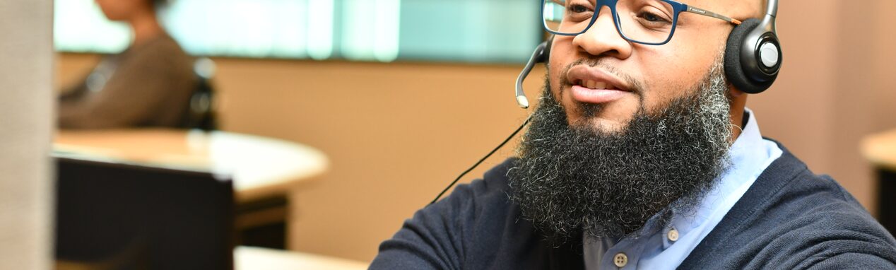 An emergency-trained OnStar advisor wearing a headset always on the lookout to assist his clients 24/7.