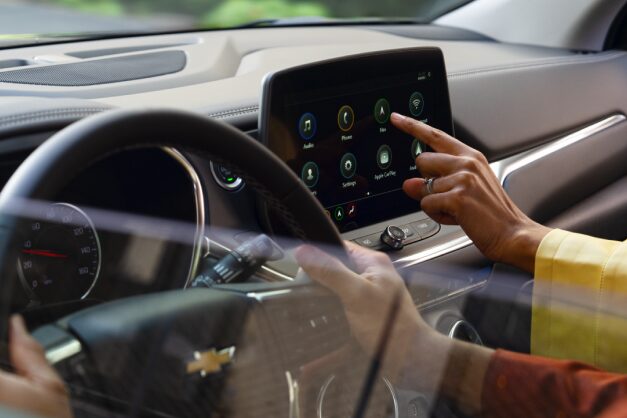 A person using the infotainment screen on a vehicle.