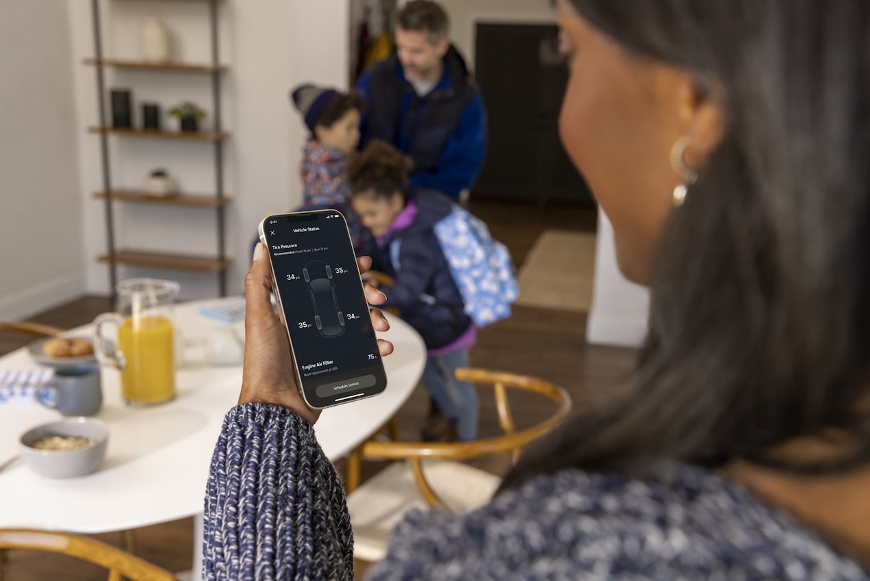 Woman using OnStar app to share the control of the vehicle with Family Members.