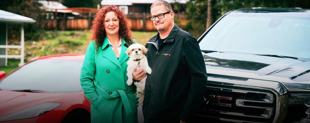 Andre Chocquette, Dixie, and his wife standing in front of the GMC Sierra 1500.