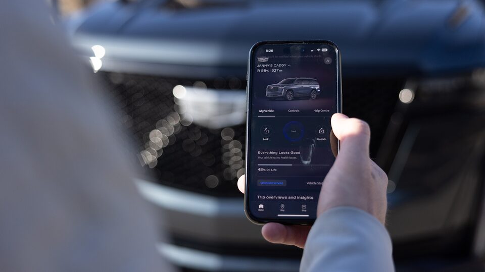 OnStar member Justin VanDyk using his smartphone inside his Cadillac SUV.