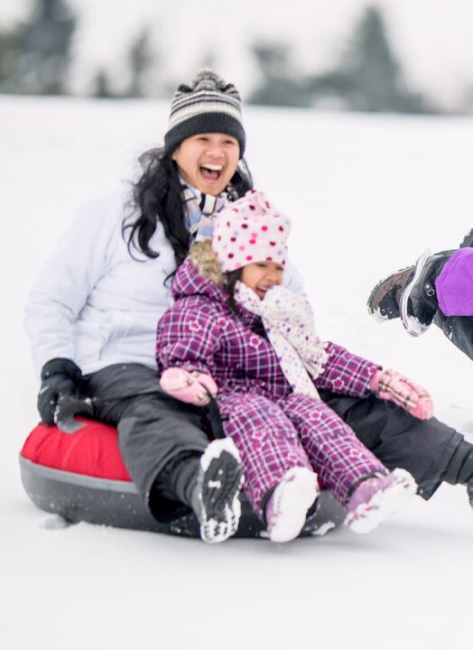 People enjoying a snow tubing ride in a local ski resort in Canada.