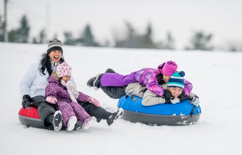 People enjoying a snow tubing ride in a local ski resort in Canada.