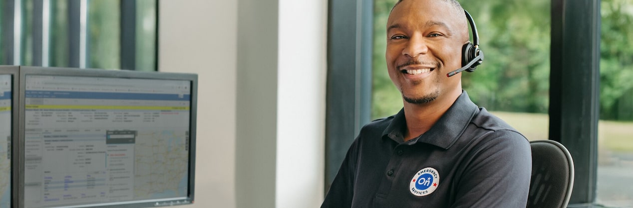 A male OnStar advisor smiling while wearing a headset.