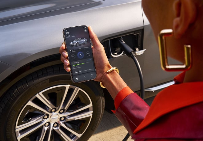 A person accessing an OnStar feature on a smartphone outside a GMC vehicle.